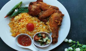 Nasi Briyani Ayam Malaysia dengan ayam berbumbu dan acar sayur