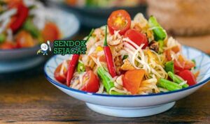 Thai Som Tam Sendok Sejagat dengan pepaya pedas.