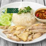 Ayam Hainan Malaysia dengan nasi kaldu, saus cabai, dan ketimun