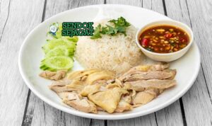 Ayam Hainan Malaysia dengan nasi kaldu, saus cabai, dan ketimun