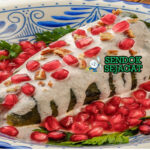 Mexican Chiles en Nogada dengan cabai poblano, saus nogada, dan biji delima