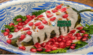Mexican Chiles en Nogada dengan cabai poblano, saus nogada, dan biji delima