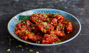 Dakgangjeong ayam goreng Korea dengan saus pedas-manis dan wijen