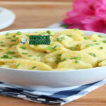 German Kartoffelsalat dengan kentang, bawang, dan sosis Jerman