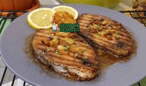 Grilled Kingfish with Wattleseed Butter dengan salad hijau dan irisan lemon