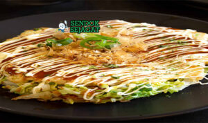 Japanese Okonomiyaki dengan saus okonomiyaki dan katsuobushi