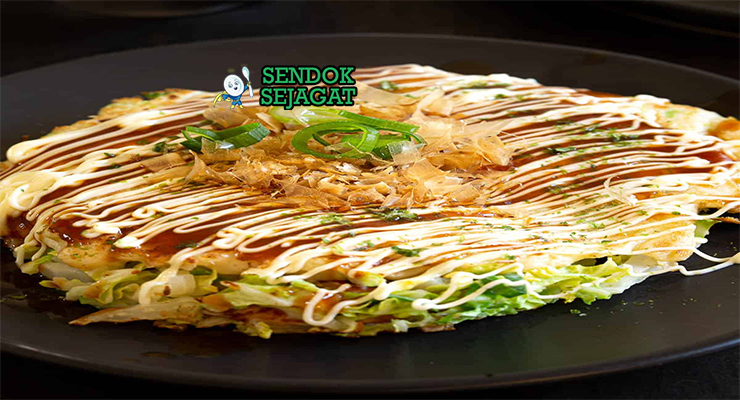 Japanese Okonomiyaki dengan saus okonomiyaki dan katsuobushi