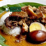 Nasi Gandul dengan daging sapi, kuah santan, dan telur rebus