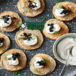 Blini dengan krim asam dan kaviar di piring saji