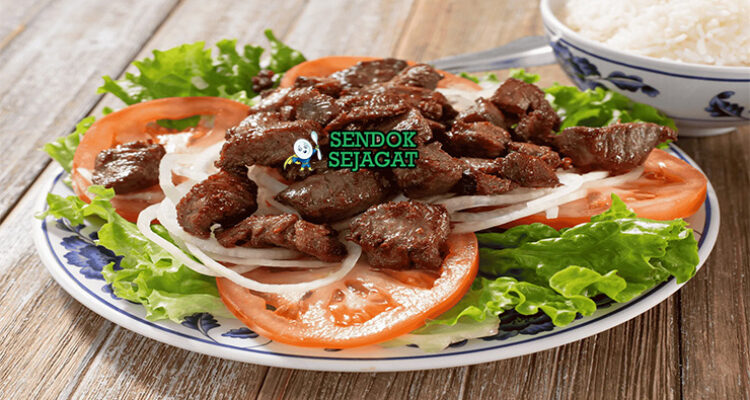 Bò Lúc Lắc dengan daging tumis dan bawang bombay di piring saji