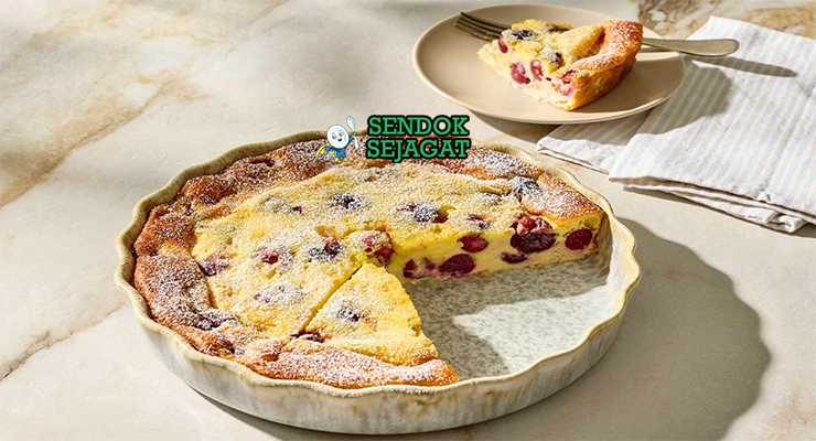 Clafoutis dengan ceri segar dan taburan gula bubuk