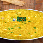 Egg Drop Soup dengan pita telur lembut di mangkuk saji
