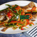 Escovitch Fish dengan acar sayuran pedas di piring saji