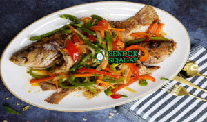 Escovitch Fish dengan acar sayuran pedas di piring saji