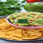 Guacamole dengan tortilla chips dan irisan jeruk nipis