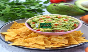 Guacamole dengan tortilla chips dan irisan jeruk nipis