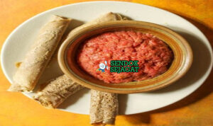 Kitfo dengan daging cincang dan injera di piring saji