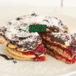 Lamington Pancakes dengan saus cokelat dan kelapa di piring saji