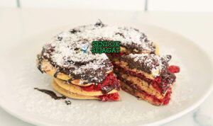 Lamington Pancakes dengan saus cokelat dan kelapa di piring saji
