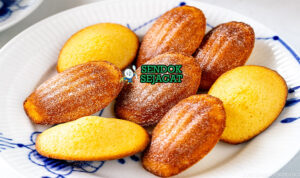Madeleines dengan bentuk shell dan taburan gula bubuk