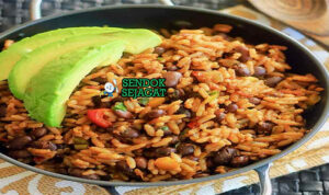 Moros y Cristianos dengan nasi kacang hitam dan daging di piring saji