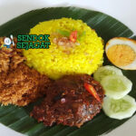 Nasi Kuning Banjar dengan ayam masak habang dan telur rebus di piring