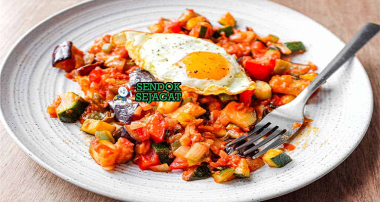 Pisto Manchego dengan tomat dan zucchini di piring saji