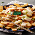Poutine dengan kentang goreng, saus keju, dan gravy di piring saji