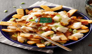 Poutine dengan kentang goreng, saus keju, dan gravy di piring saji