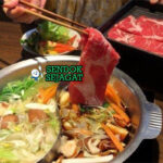 japanese Shabu Shabu dengan daging tipis dan sayuran di panci kaldu