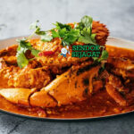 Singaporean Chilli Crab dengan saus tomat pedas dan garnish daun bawang