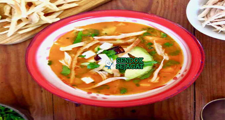 Sopa Azteca dengan tortilla renyah dan hiasan alpukat di mangkuk saji
