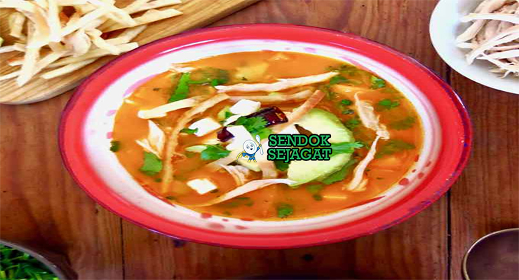 Sopa Azteca dengan tortilla renyah dan hiasan alpukat di mangkuk saji