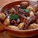 Afelia dengan daging babi anggur dan bulgur di piring saji