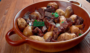 Afelia Daging Babi Anggur Khas Siprus Afelia dengan daging babi anggur dan bulgur di piring saji
