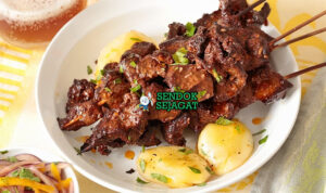 Anticuchos Pedas Khas Peru Anticuchos dengan sate daging dan saus aji panca di piring saji