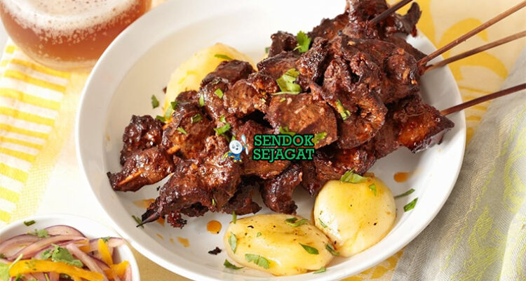 Anticuchos dengan sate daging dan saus aji panca di piring saji