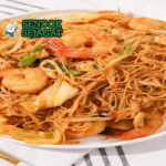 Bihun Goreng bihun tumis udang wortel kol telur kecap daun bawang di piring saji