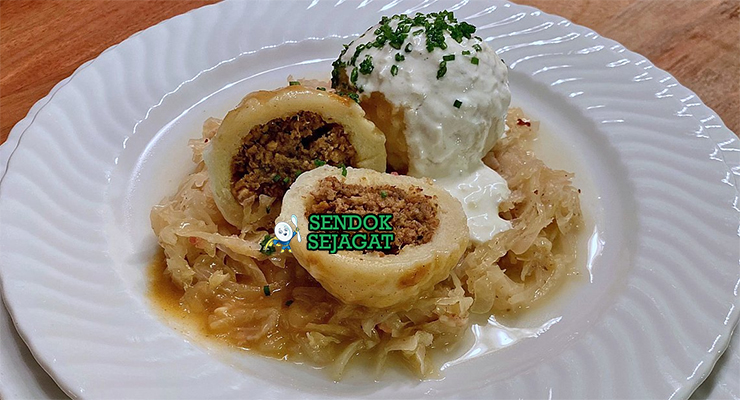 Bratknödel dengan pangsit roti dan saus krim di piring saji