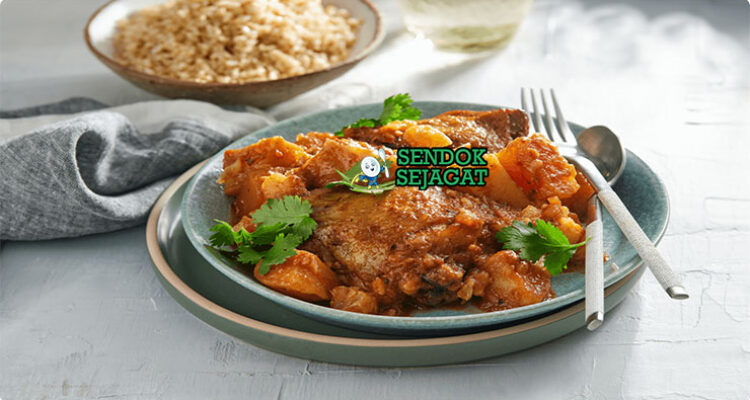 Cape Malay Curry ayam rempah aprikot yogurt atas nasi di mangkuk saji