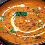 Dal Makhani kacang hitam krim mentega dengan naan di mangkuk saji