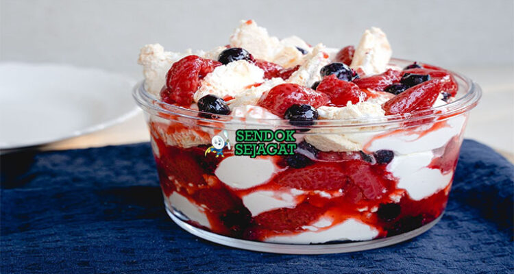 Eton Mess meringue dengan krim dan stroberi di mangkuk saji