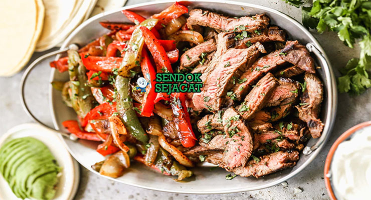 Fajitas Daging Tumis Paprika Khas Meksiko Fajitas daging iris tumis paprika sizzling di wajan besi dengan tortilla