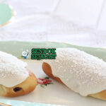 Finger Bun roti manis dengan glasur merah muda dan kelapa di piring saji