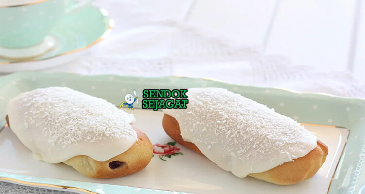 Finger Bun roti manis dengan glasur merah muda dan kelapa di piring saji