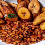 Ghanaian Red Red dengan kacang merah dan pisang goreng di piring saji