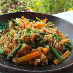 Gudangan dengan sayuran rebus dan saus kelapa di piring saji