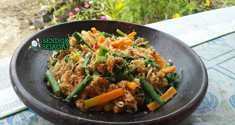 Gudangan dengan sayuran rebus dan saus kelapa di piring saji