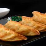 Gyoza dumpling goreng renyah isi daging dengan saus cuka di piring saji