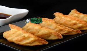Gyoza Renyah Juicy Khas Jepang Gyoza dumpling goreng renyah isi daging dengan saus cuka di piring saji